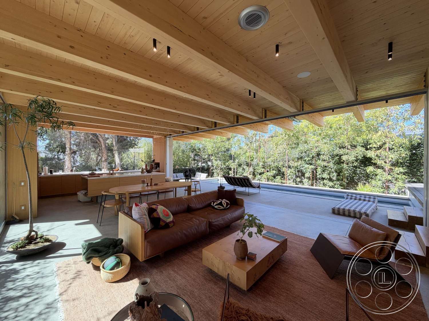 Retro House - minimalist decor, natural light, exterior, wood coffee table, textured area rug, open floor plan, modern furniture, wood dining table, floor-to-ceiling windows, lush greenery view, exposed wood ceiling beams, concrete patio flooring, steel dining chairs, neutral fabric sofa