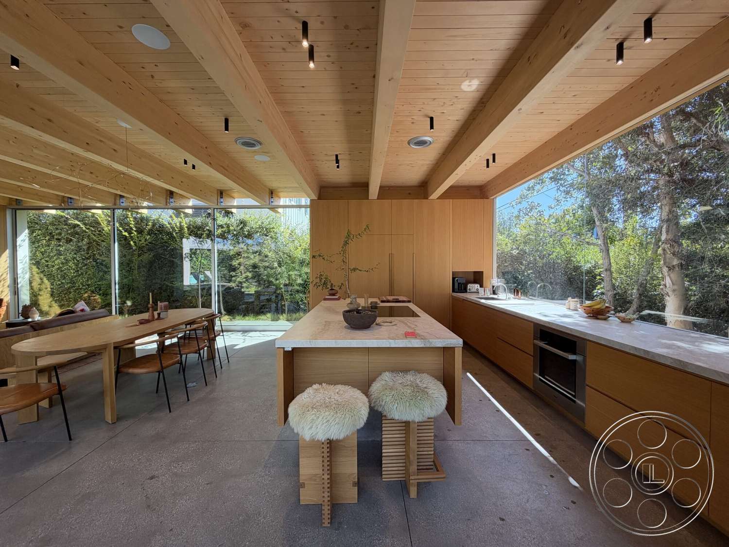 Retro House - minimalist aesthetic, concrete floor, wood dining table, open-plan layout, modern kitchen design, exposed wood ceiling beams, marble kitchen island countertop, integrated kitchen appliances, light wood paneling walls, wood dining chairs with metal legs, glass walls providing outdoor views, lush greenery view from windows