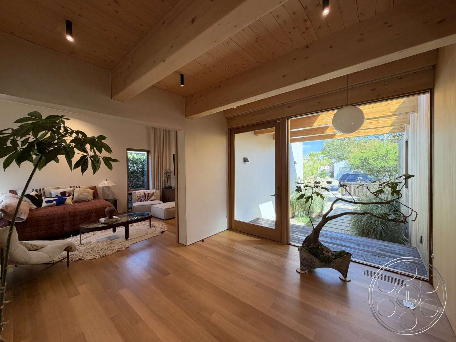 Retro House - neutral color palette, open floor plan, integrated indoor-outdoor space, large windows for natural light, soft textile accents, hardwood living room floors, modern minimalist design, white painted walls, glass door entry, contemporary indoor plant decor, light wood beam ceiling, cozy living room setup