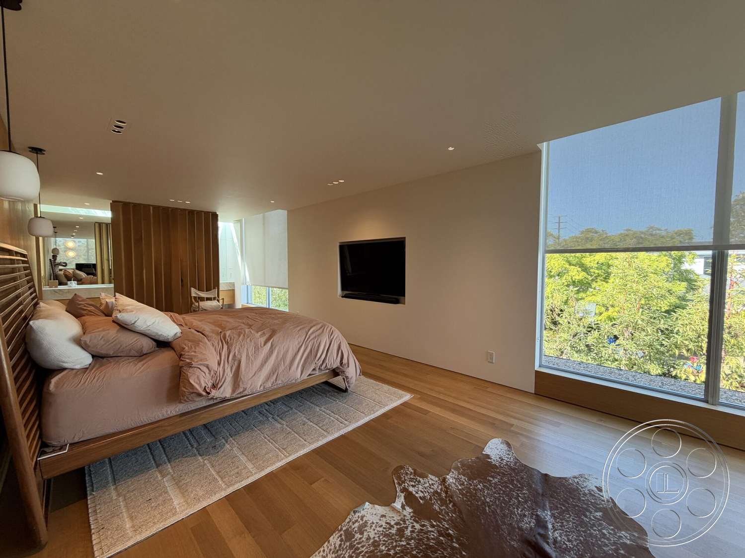 Retro House - textured area rug, floor-to-ceiling windows, natural light interior, minimalist interior design, hardwood bedroom floors, wood slatted accent wall, modern wall-mounted television, king-size bed with beige bedding