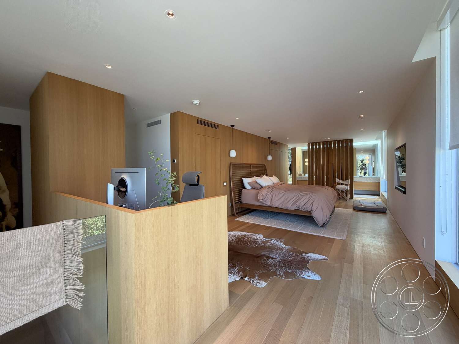 Retro House - decorative area rug, neutral wall colors, open floor plan, plush bedding, textured throw blanket, natural light from windows, recessed ceiling lighting, contemporary furniture design, hardwood bedroom floors, built-in shelving unit, wood paneling accents, decorative artwork on walls, minimalist room decor, seating area with accent chair, wooden room divider