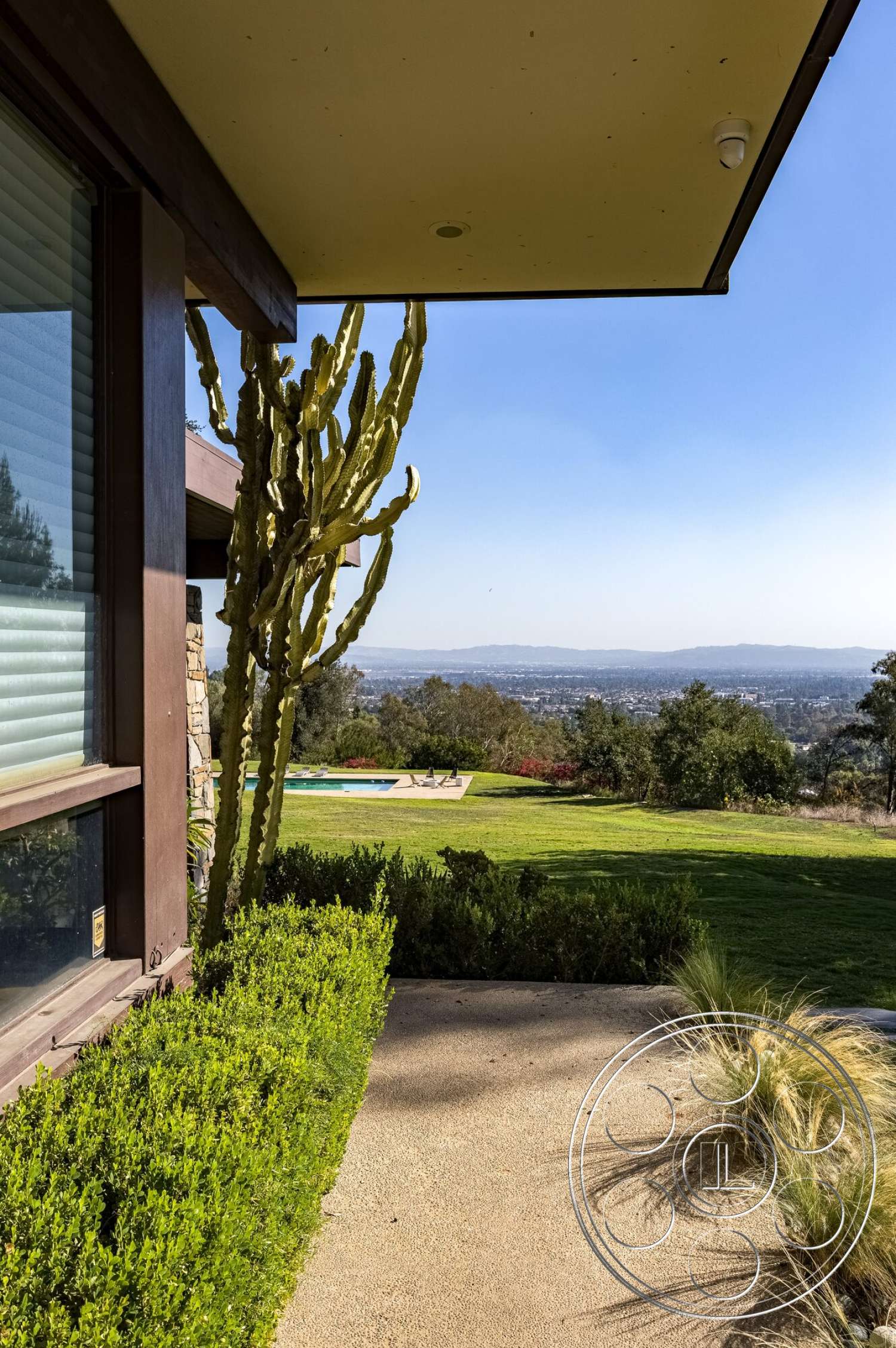 MCM 29 - exterior, flat roof, smooth concrete surface, pool area, modern architectural style, mountain view, desert plants, cacti plants, grass landscaping, sliding glass windows, textured stucco wall, concrete patio walkway, wood trim fascia