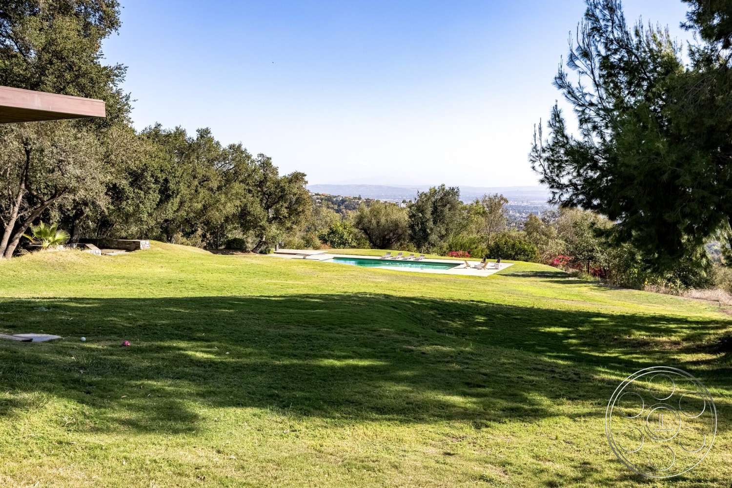 MCM 29 - exterior, surrounding trees, grass lawn, city skyline view, concrete pool deck, hillside location, in-ground rectangular pool