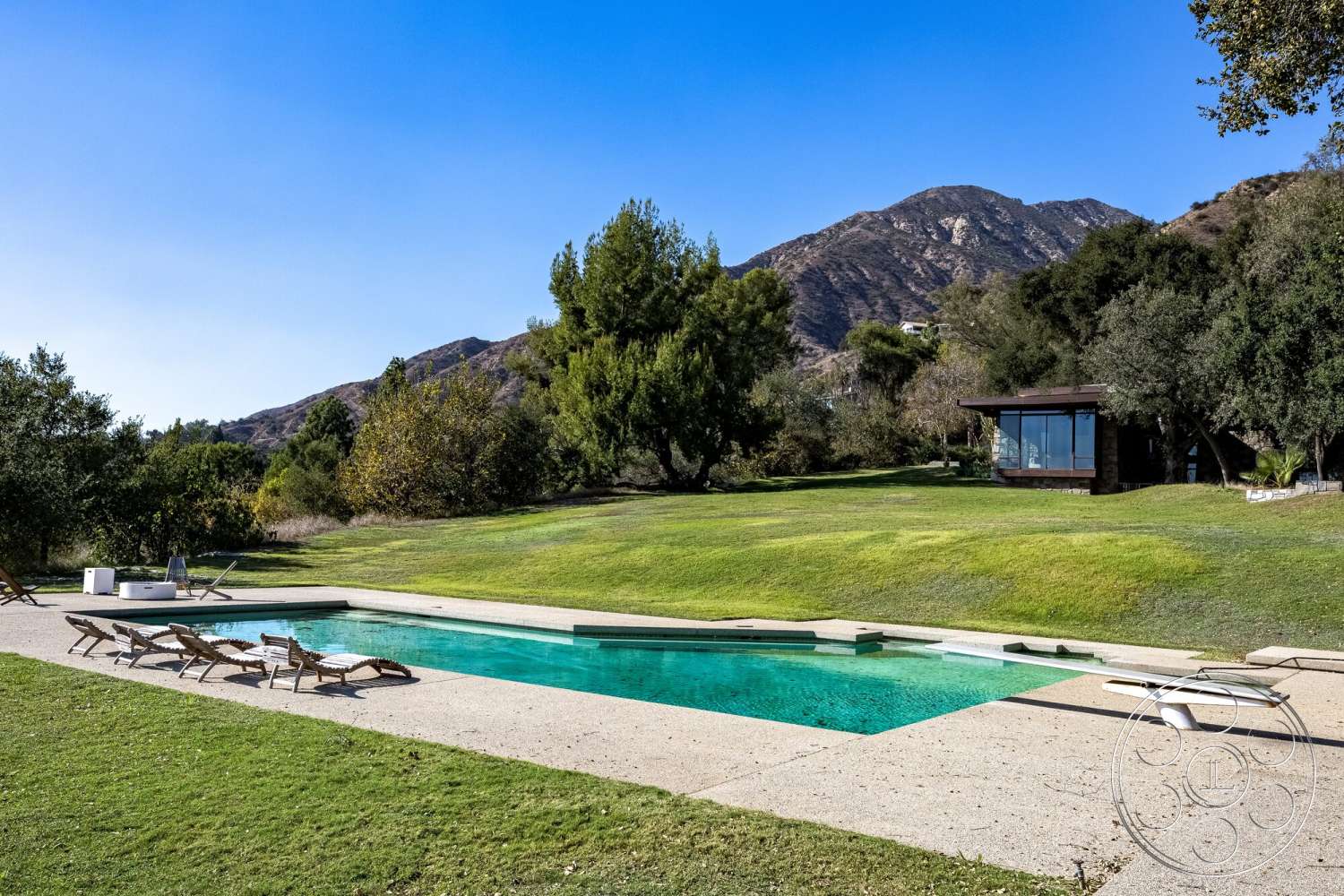 MCM 29 - exterior, landscaped garden, minimalist design, outdoor seating area, glass windows, grass lawn, mountain view, rectangular pool, wooden lounge chairs, concrete pool border, concrete patio floor, modern pool area