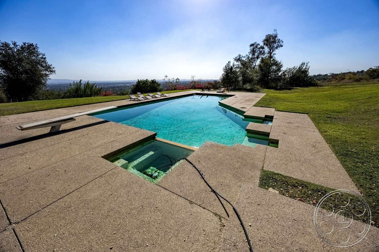 MCM 29 - exterior, rectangular swimming pool, geometric design, open outdoor space, lawn area, mountain view, concrete pool deck, clean modern lines, landscape with trees, sunbathing area with loungers, clear pool water