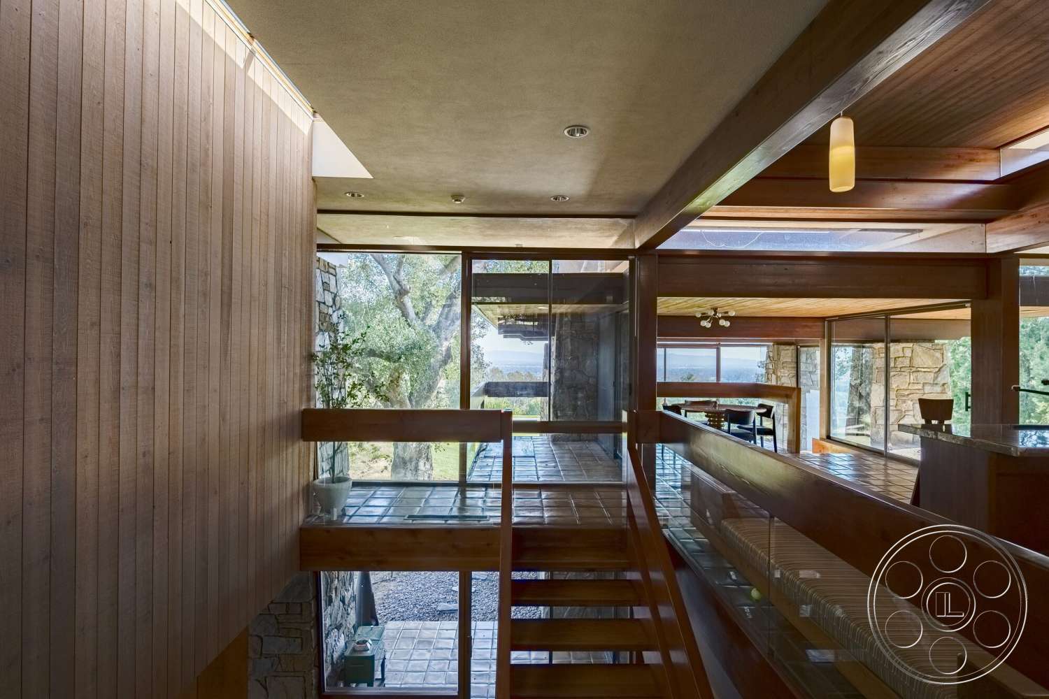 MCM 29 - natural light, modern architecture, open living space, concrete ceiling, stone feature wall, exposed wood ceiling beams, glass partition walls, wood paneling walls, floating wood staircase, tile floor entryway, forest view