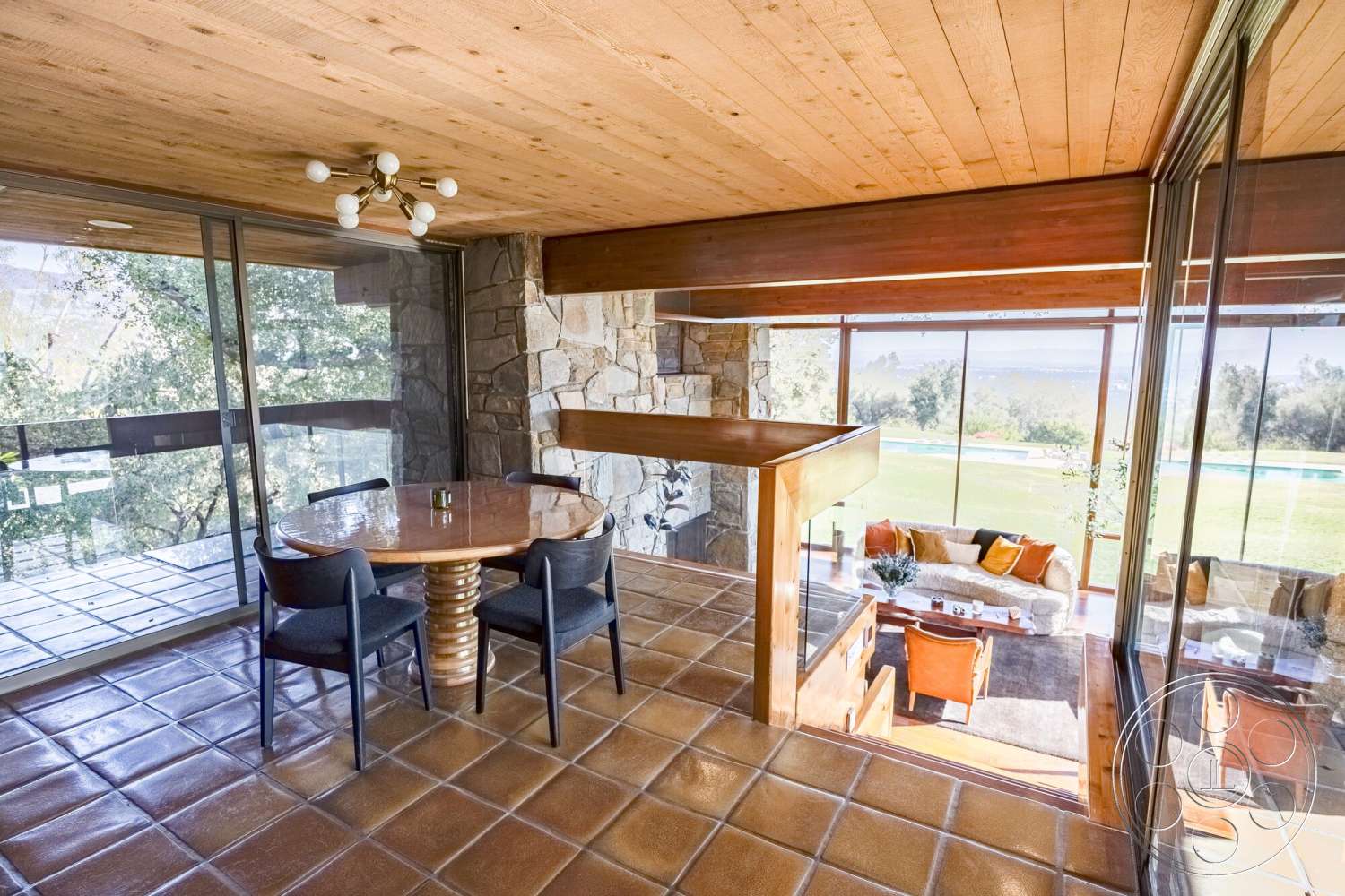 MCM 29 - tile flooring, exterior, open floor plan, glass sliding doors, floor-to-ceiling windows, modern lighting fixture, stone feature wall, circular dining table, wood beam ceiling, urban backyard view, rustic dining area, wood accent details