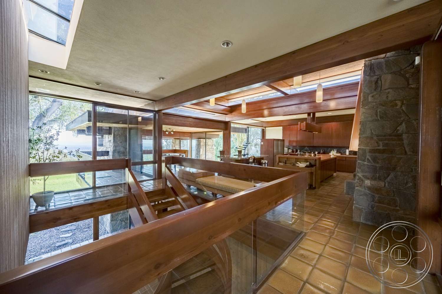 MCM 29 - natural light, stone accent wall, ceramic tile flooring, panoramic view, contemporary design elements, open concept living space, exposed wood ceiling beams, modern kitchen cabinetry, integrated lighting fixtures, glass window walls, vaulted ceiling design, flowing indoor-outdoor transition, wooden railing staircase, wood beam architecture
