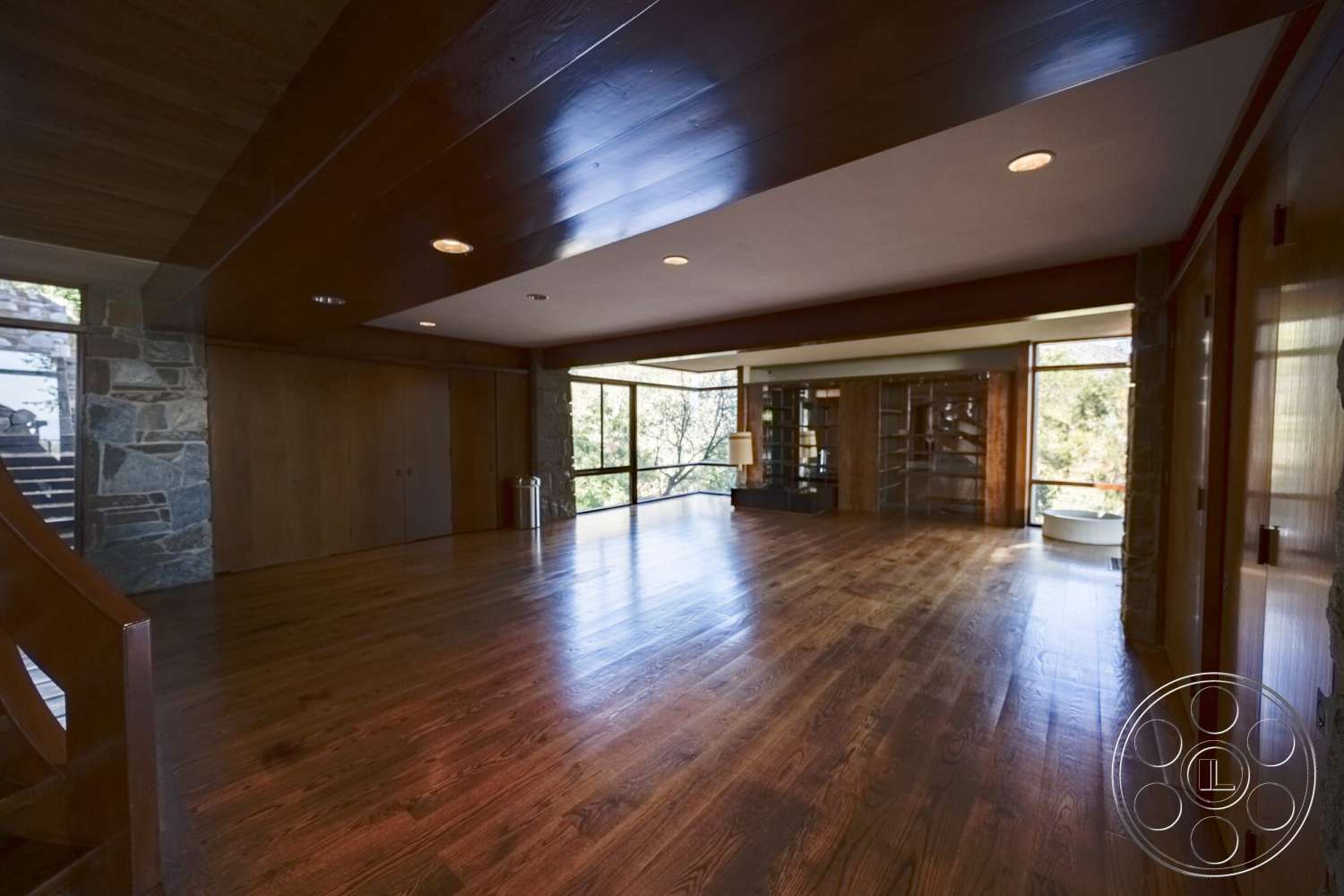 MCM 29 - natural light, stone accent wall, open floor plan, floor-to-ceiling windows, vaulted ceiling, modern architectural style, contemporary interior, exposed wood ceiling beams, hardwood living room floors, built-in shelving units