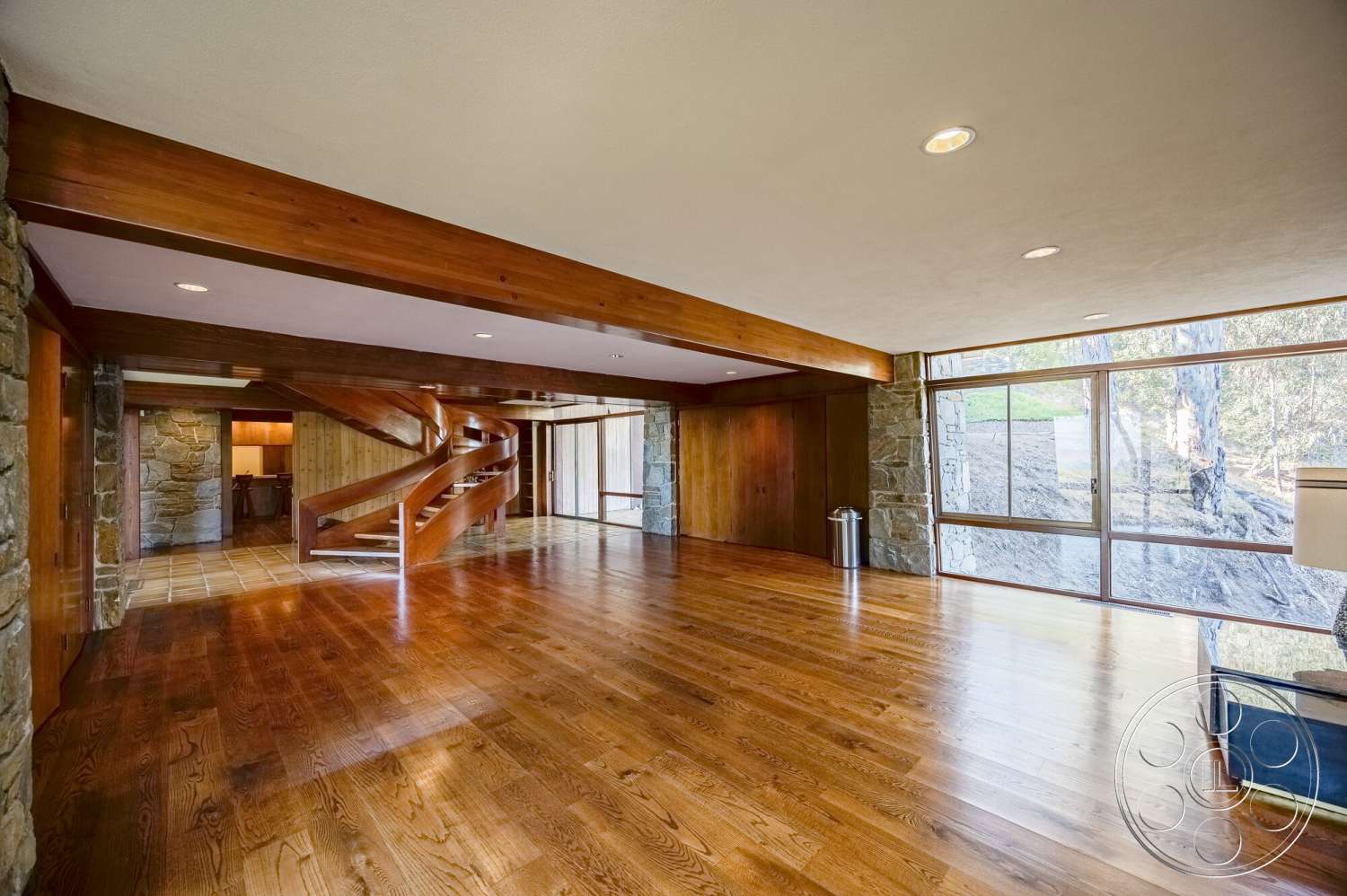 MCM 29 - natural light, hardwood flooring, exposed wood beams, textured plaster ceiling, large floor-to-ceiling windows, mid-century modern style, stone feature wall, curved staircase, open concept living area