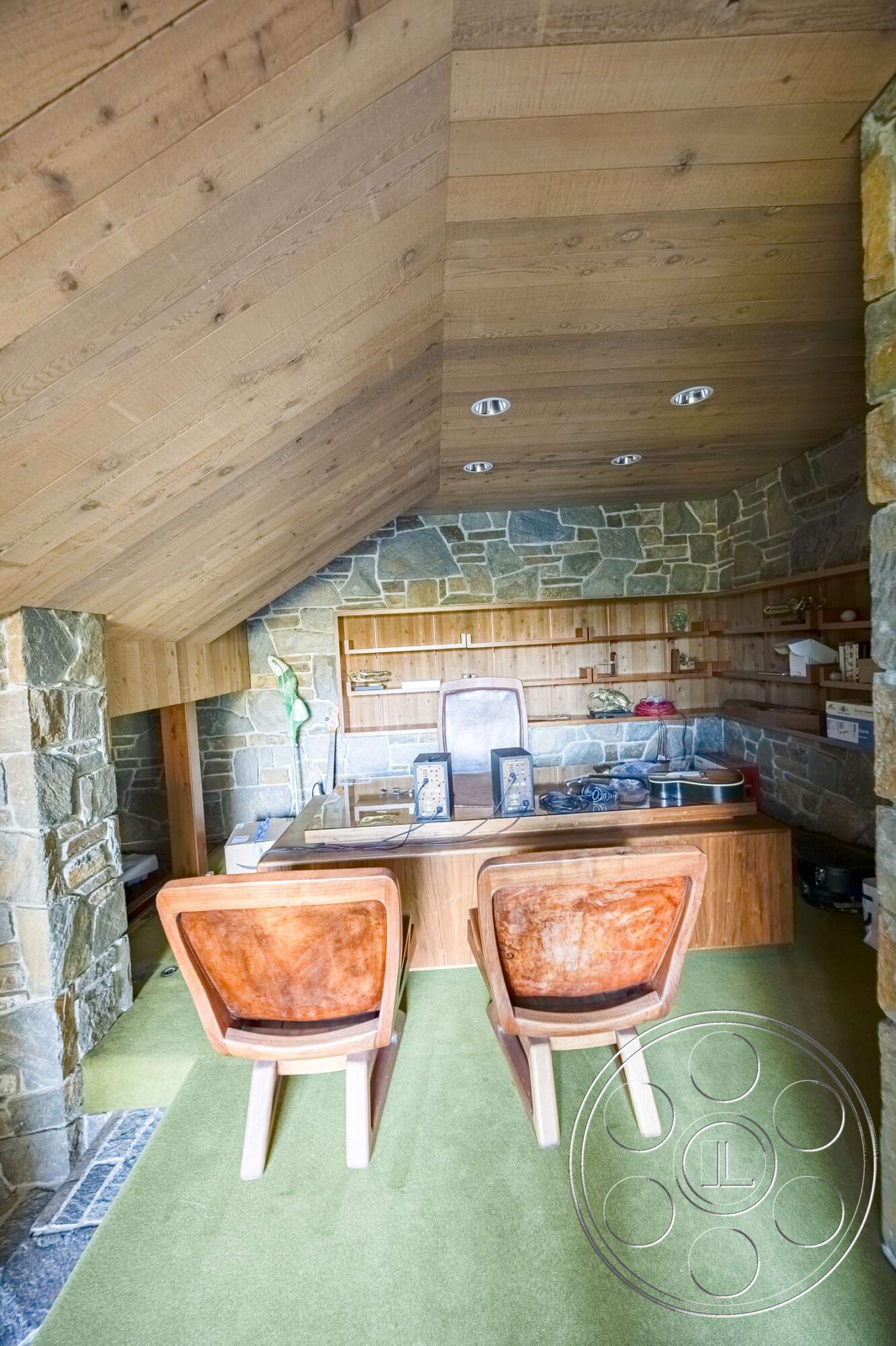 MCM 29 - exterior, natural wood paneling, contemporary desk, mid-century modern chairs, built-in wooden cabinetry, green carpet flooring, exposed stone walls, wooden sloped ceiling