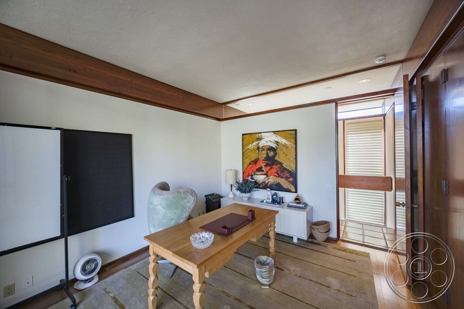 MCM 29 - textured area rug, exposed wood ceiling beams, white painted walls, framed artwork on wall, hardwood office floors, decorative table accessories, modern wooden table, glass tabletop accent, open door with wood detailing, sliding glass door hardware, blackboard wall feature