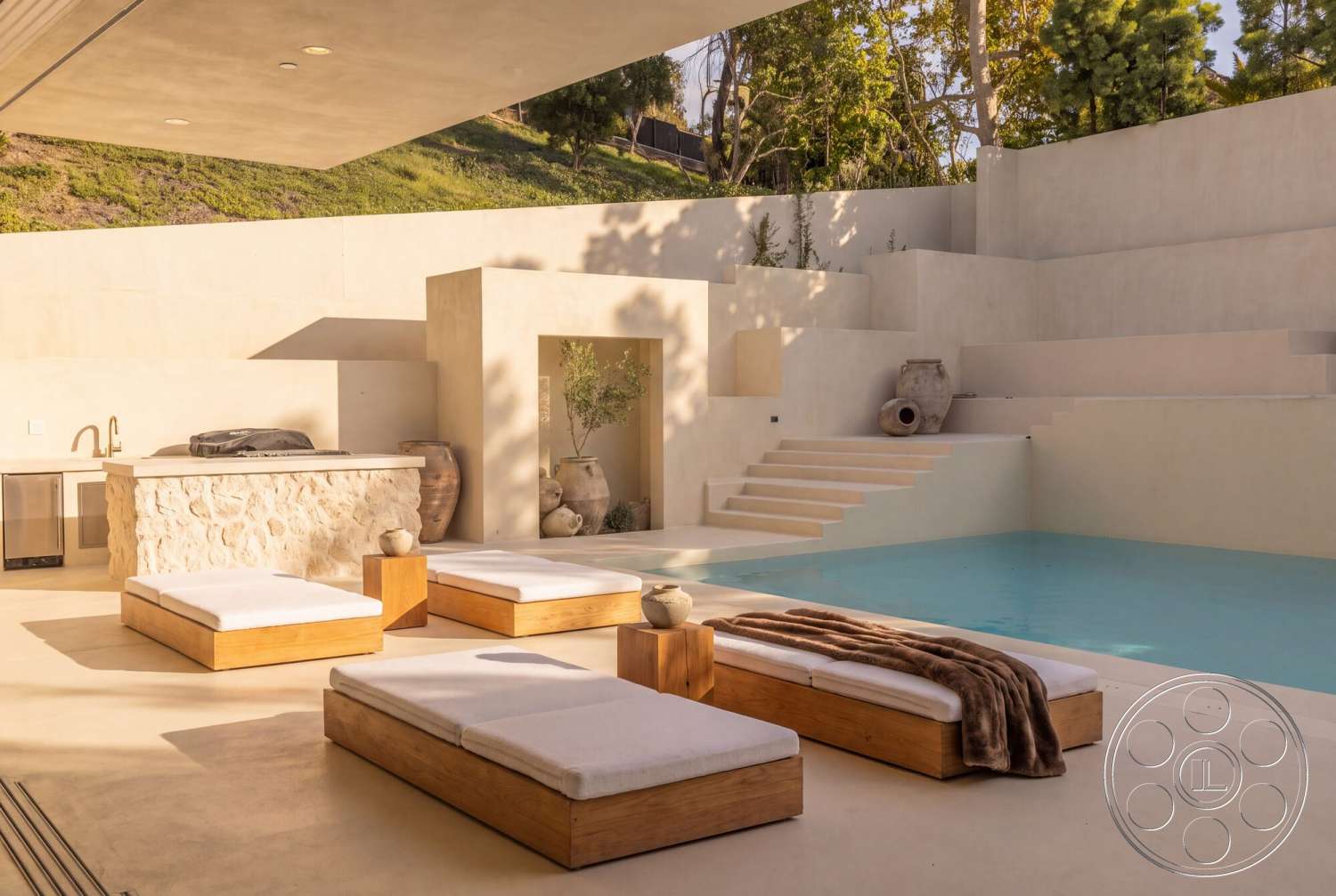Modern 535 - exterior, concrete walls, concrete pool deck, rectangular pool, tree-lined backdrop, modern minimalist design, contemporary outdoor living space, landscaped hillside setting, built-in planters, white stucco finish, textured wall accent, upholstered outdoor cushions, wood lounge chairs, steps leading to pool area, natural stone outdoor kitchen island