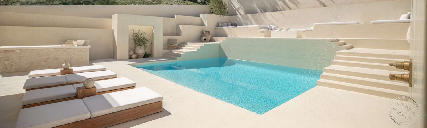 Modern 535 - exterior, textured concrete walls, infinity pool, concrete pool deck, natural stone planters, sunny outdoor environment, minimalist landscape design, concrete pool steps, wood lounge chairs, horizontal seating area, stainless steel faucets, white upholstery on lounge chairs, shaded lounge area, modern outdoor aesthetics