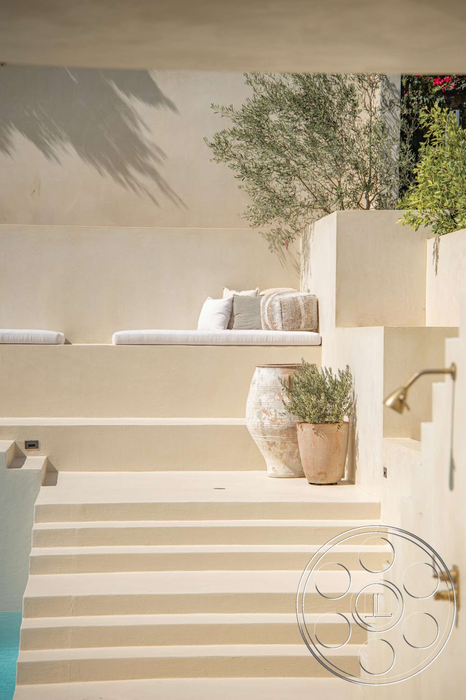 Modern 535 - exterior, soft neutral color palette, minimalist design elements, landscaped greenery, concrete steps, natural stone planters, stucco wall treatment, rectangular seating area, organic-shaped planters, textured patio area