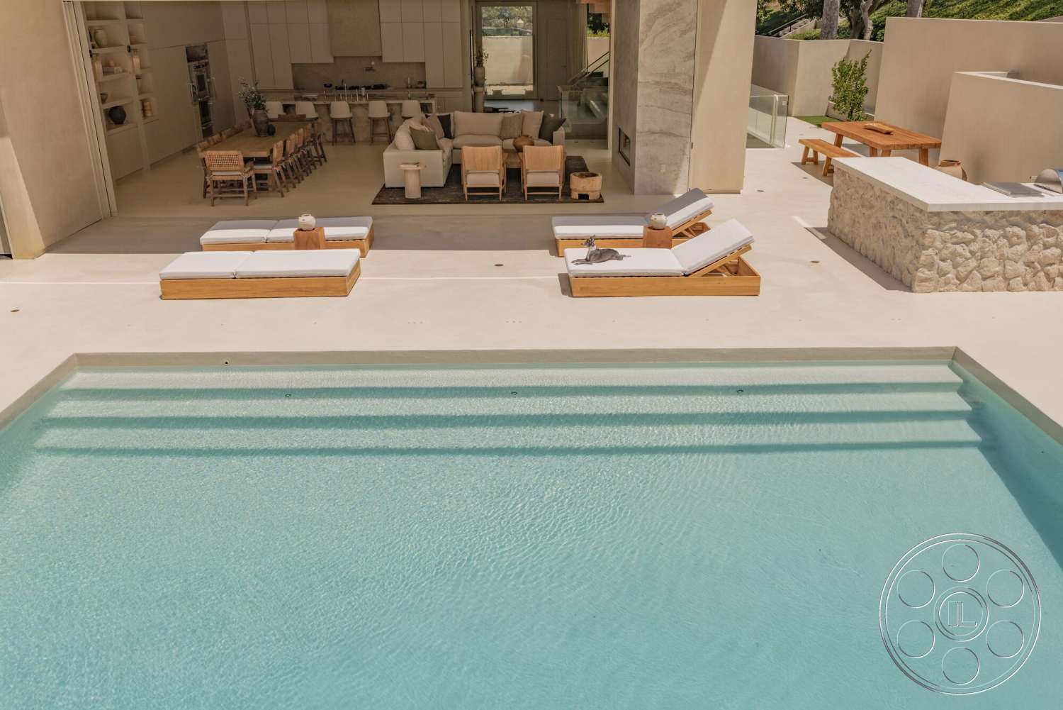 Modern 535 - exterior, modern outdoor furniture, rectangular pool, open-plan layout, landscaped garden area, concrete patio flooring, minimalist architectural style, floor-to-ceiling glass doors, stone outdoor kitchen counter, wooden sun loungers, neutral-tone color palette