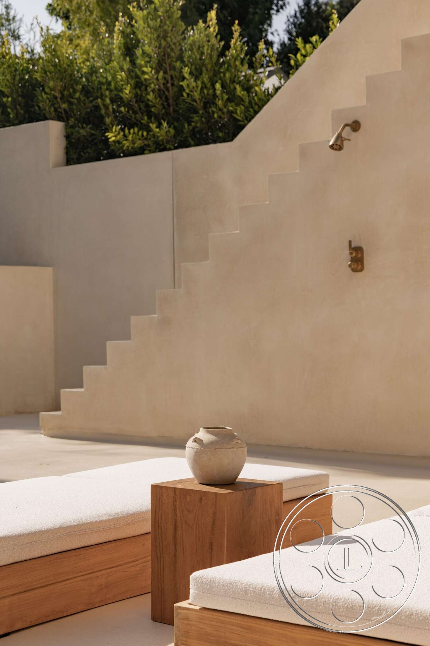 Modern 535 - exposed concrete walls, modern aesthetic, wooden side table, stucco exterior, ceramic planter, wooden lounge chairs, light-colored cushions, interior setting, sunlit patio area, rectangular outdoor steps, soft landscape plants
