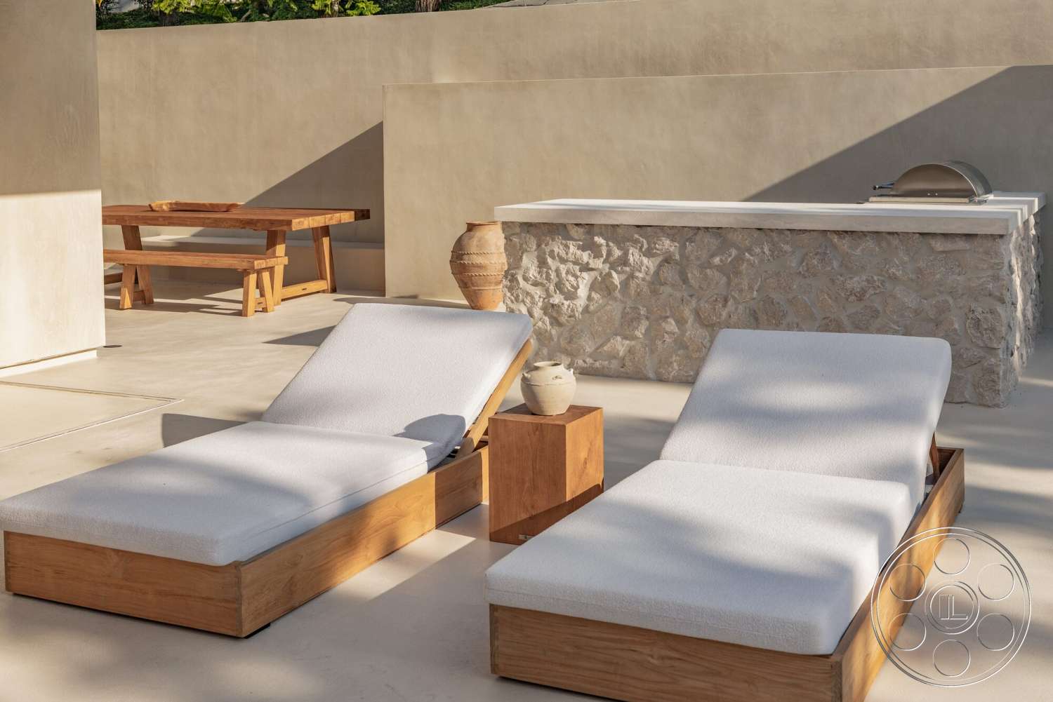 Modern 535 - exterior, wooden lounge chairs, concrete patio flooring, textured plaster wall, rectangular outdoor dining table, stone outdoor kitchen counter, natural wood side table, exposed aggregate stone wall, woven outdoor cushions, ceramic decorative vase