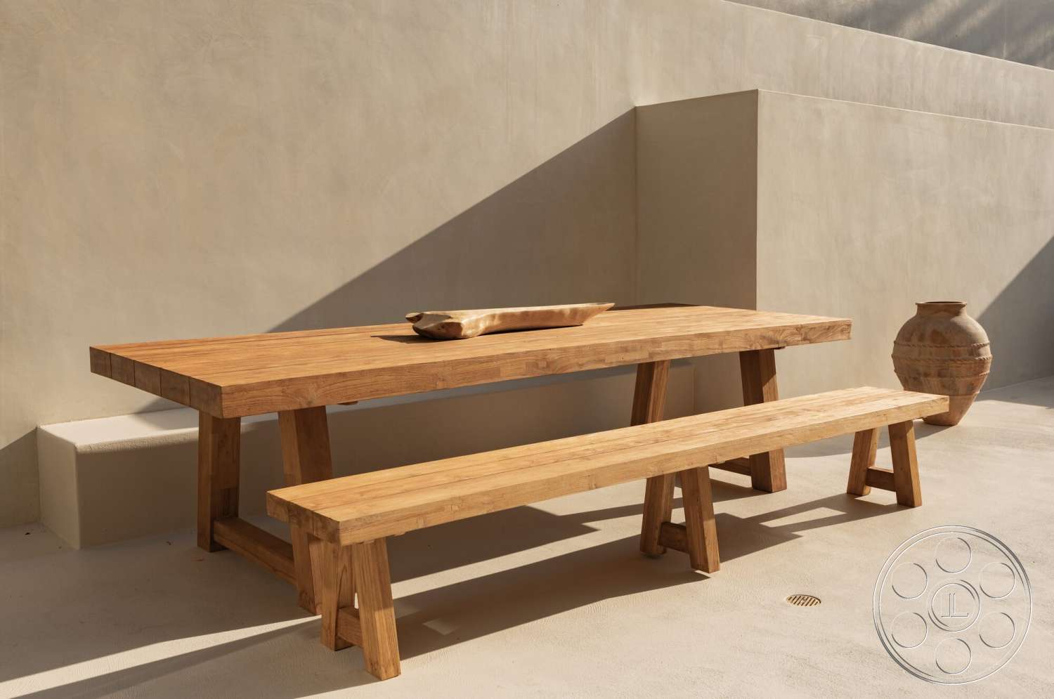 Modern 535 - concrete floor, wood dining table, exterior space, outdoor dining area, modern minimalist design, textured plaster wall, wood bench seating, natural wood grain texture, ceramic decorative vase, sunlit patio setting
