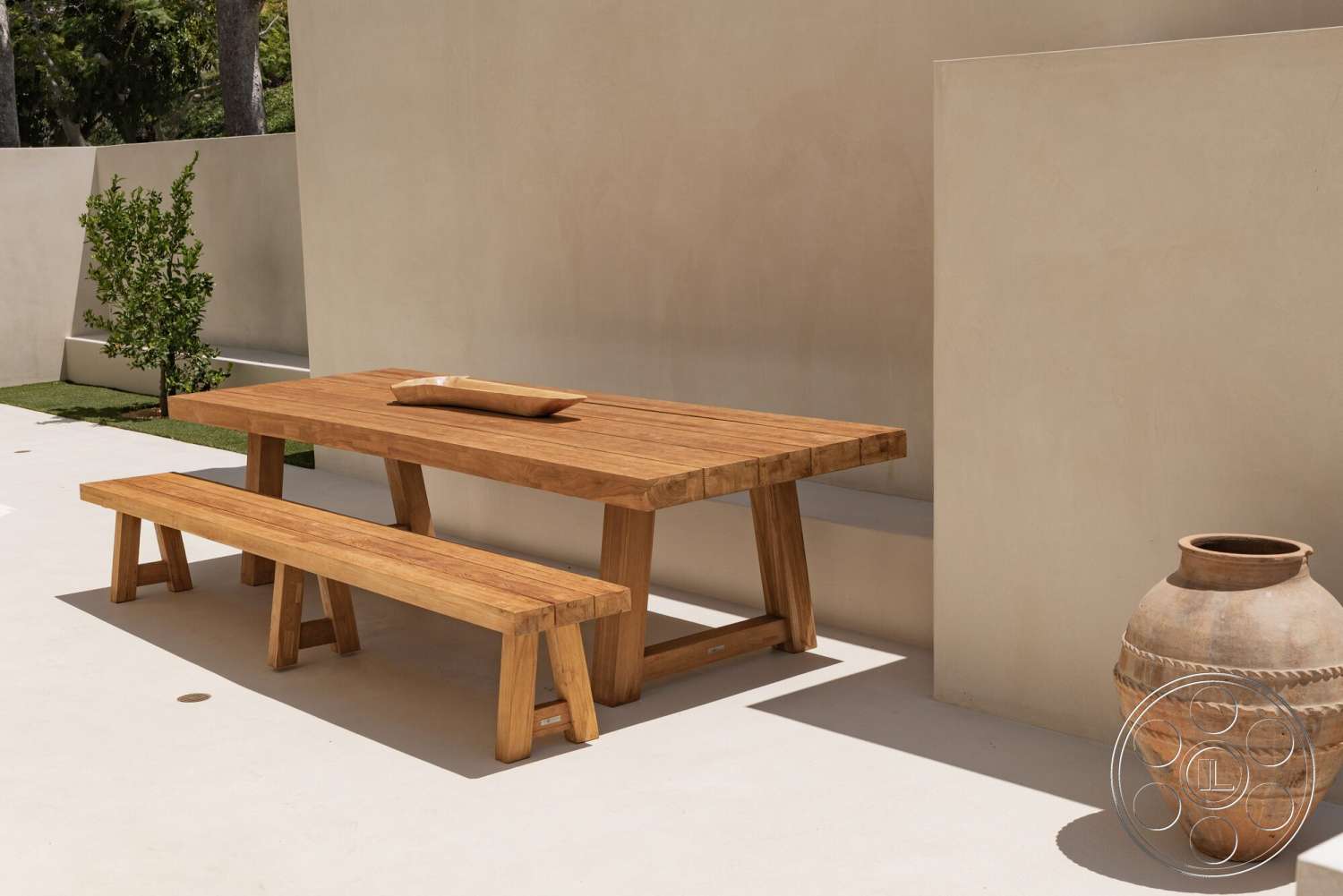 Modern 535 - exterior, wood dining table, green landscaping, wood bench, stucco wall, decorative ceramic vase, textured plaster wall, exposed aggregate concrete patio, minimalist outdoor setting