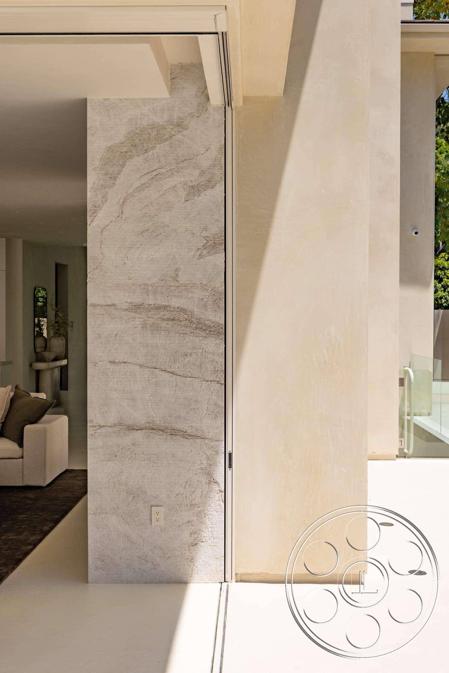 Modern 535 - exterior, modern architectural style, textured stone feature wall, concrete patio floor, smooth stucco wall finish, natural light-filled entryway, floor-to-ceiling glass door