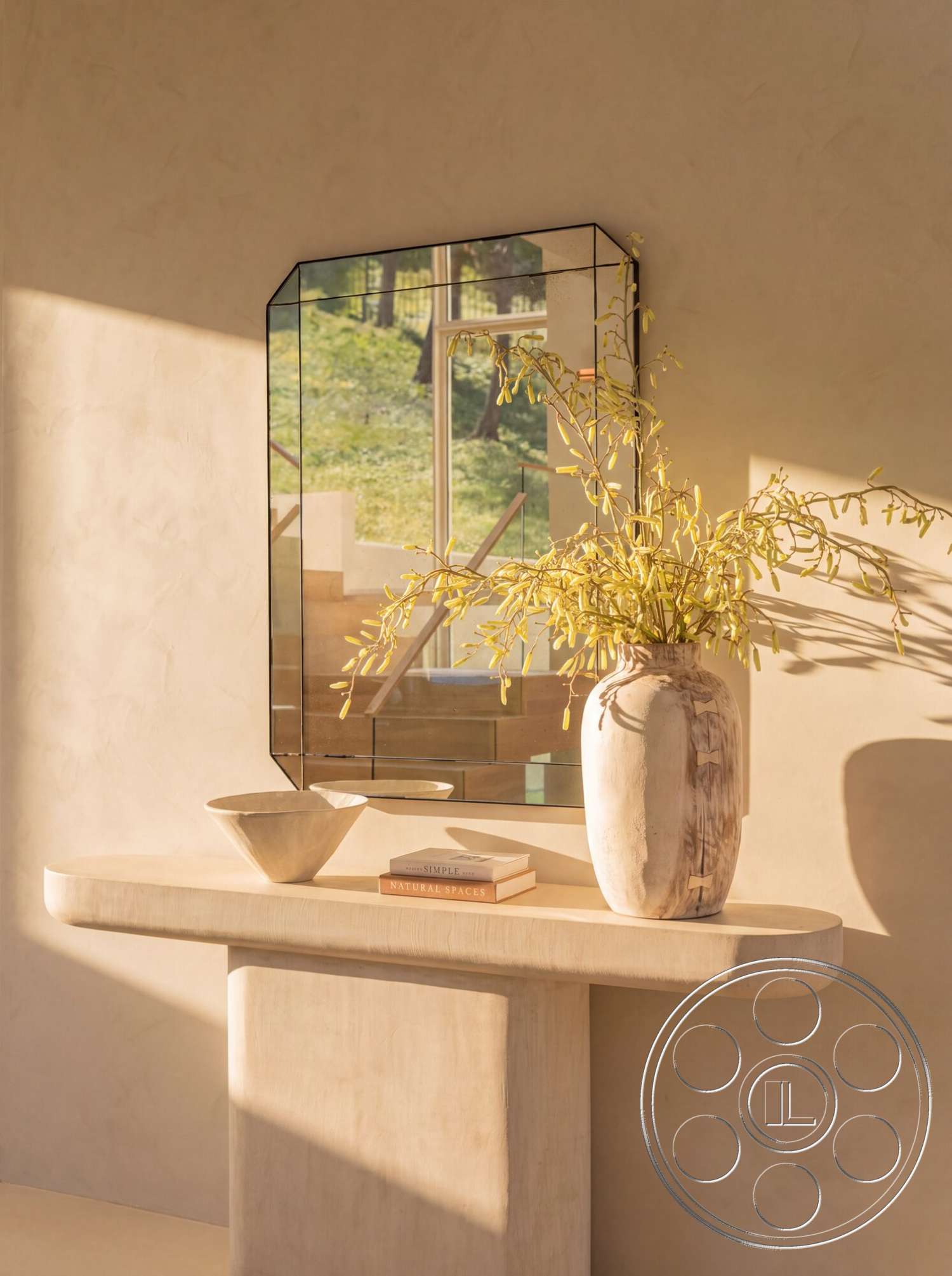 Modern 535 - large windows, warm color palette, soft natural lighting, natural landscape view, ceramic bowl, textured plaster wall, dried floral arrangement, minimalist console table, rounded-edge wooden tabletop, concrete table base, rectangular mirror with metal frame, tall ceramic vase, open staircase in background