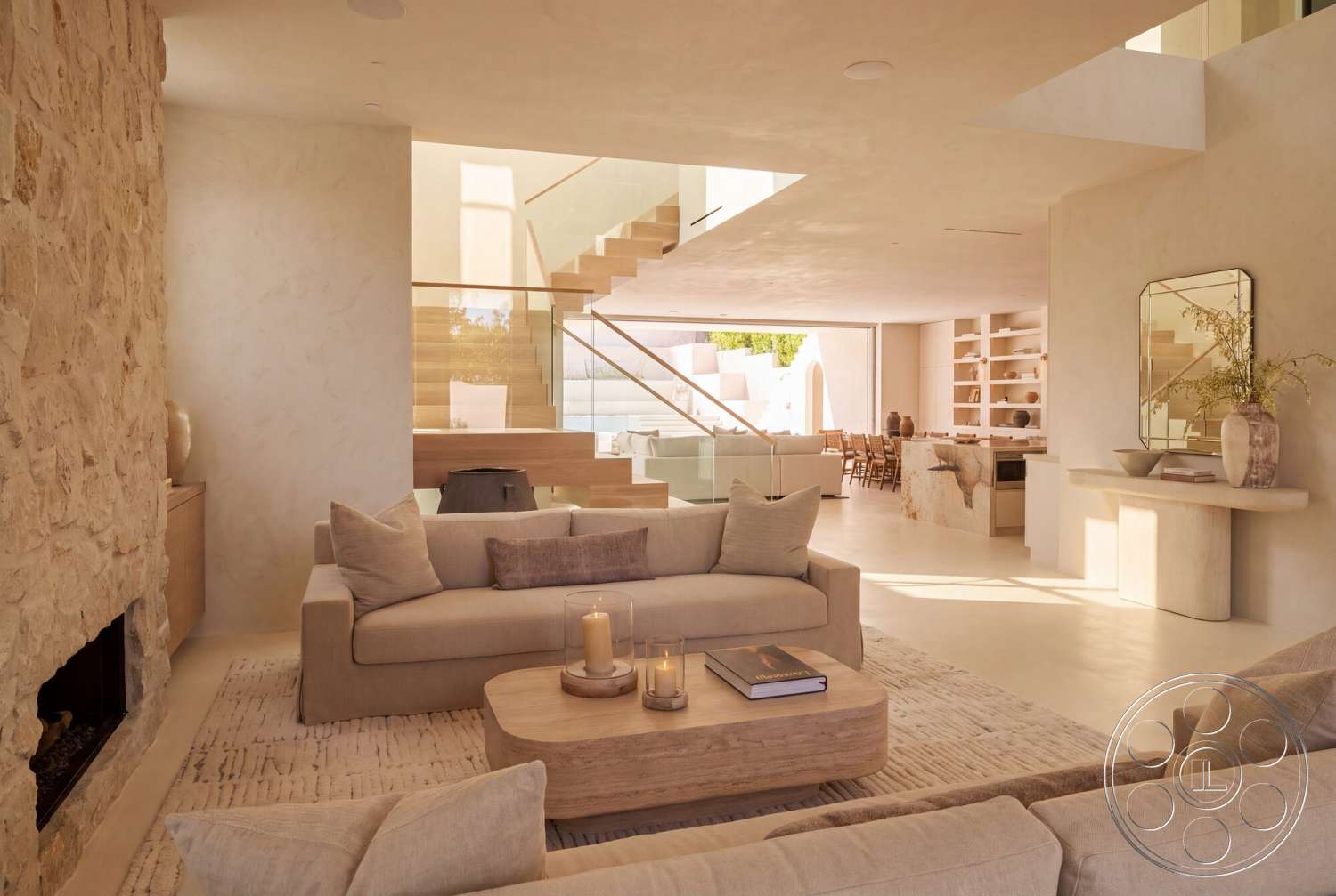 Modern 535 - minimalist decor, neutral color palette, textured area rug, open floor plan, natural wood cabinetry, concrete flooring, wooden dining table, large windows for natural light, glass railing, plaster walls, round wooden coffee table, floating staircase, indoor potted plants, beige upholstered sofa, exposed stone fireplace wall, modern wall mirror