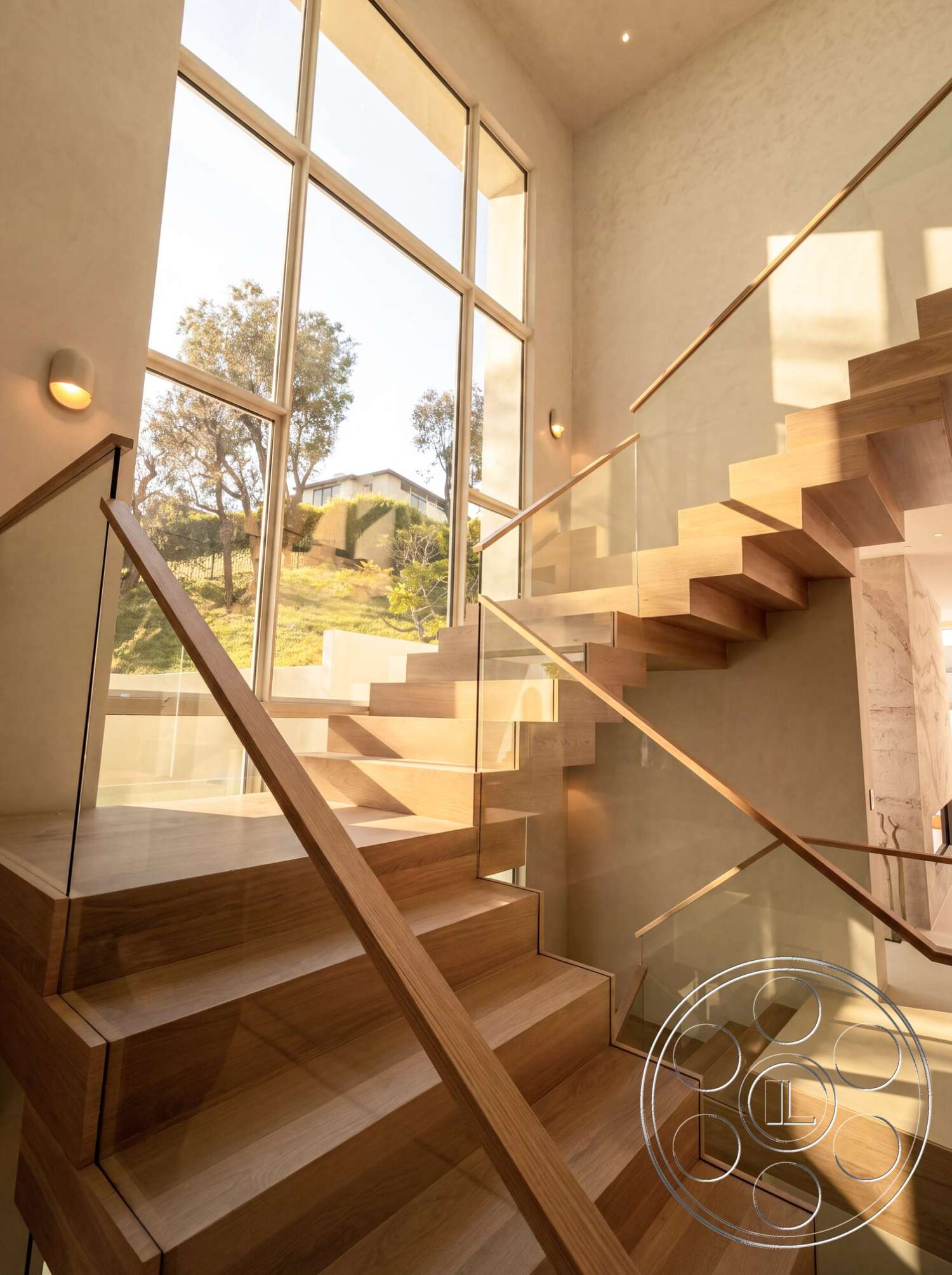 Modern 535 - modern lighting fixtures, textured plaster walls, large floor-to-ceiling windows, light-filled space, contemporary home design, minimalist architectural style, floating wood staircase, open stairwell, glass stair railings, natural oak wood steps