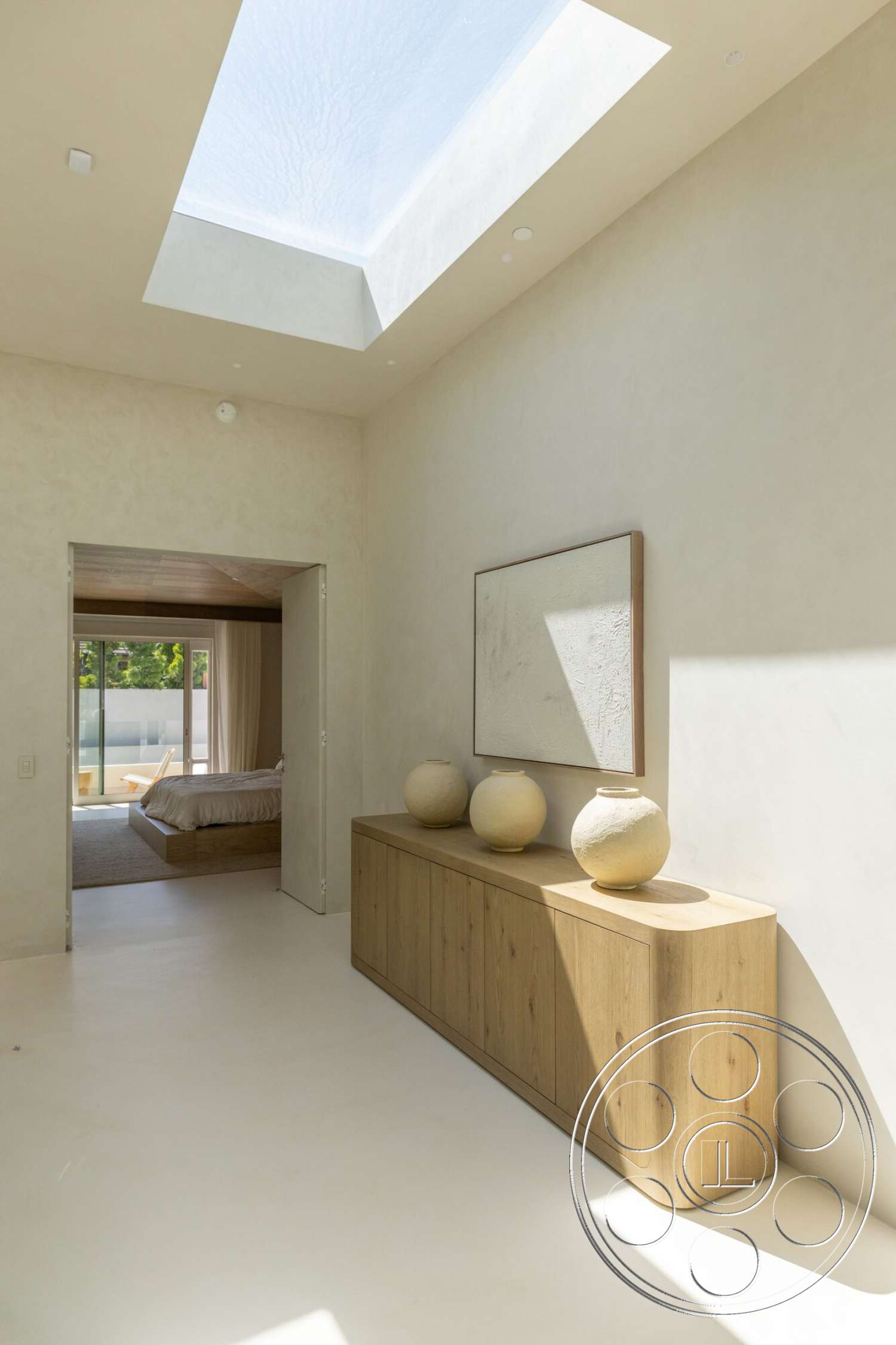 Modern 535 - minimalist decor, smooth concrete flooring, soft natural light, plastered walls, textured wall treatment, white painted walls, floating wood sideboard, natural wood sideboard, designed skylight