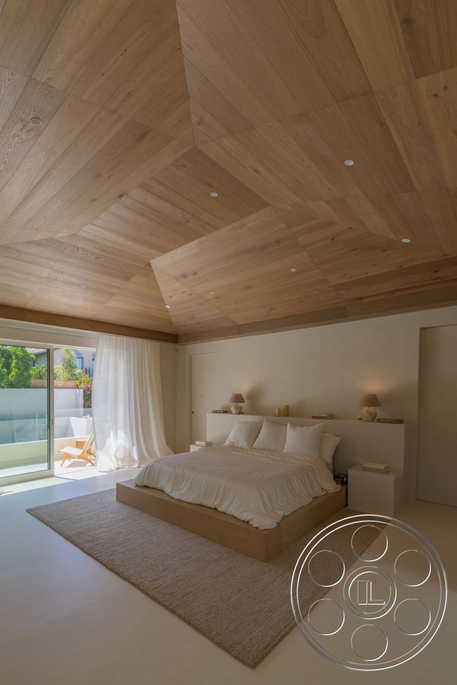 Modern 535 - textured plaster walls, carpet bedroom flooring, contemporary bedroom, hardwood ceiling planks, natural light from large glass doors, minimalist bed design, calm interior setting, bedside table with lamps, window with sheer white curtains