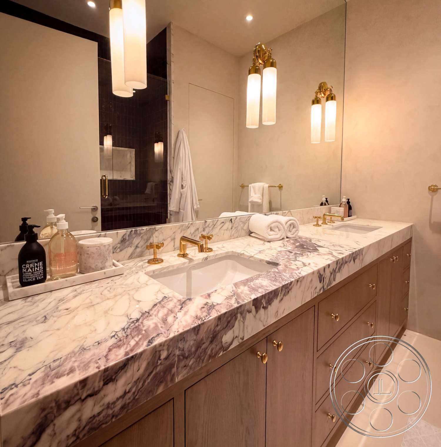 Modern 535 - neutral color palette, double sink vanity, marble countertop, textured plaster walls, gold faucet fixtures, wall-mounted light fixtures, large wall mirror, wood bathroom cabinetry, ceiling lighting