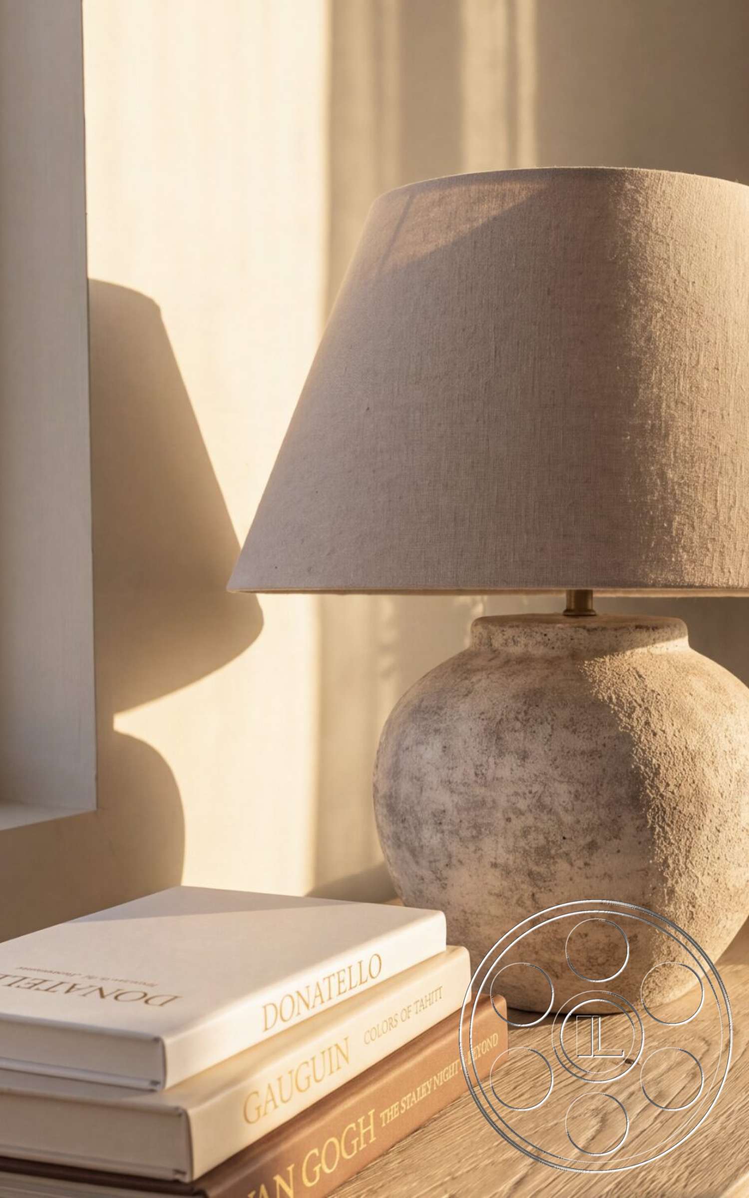 Modern 535 - minimalist decor, neutral color palette, wooden table surface, ceramic lamp base, linen lamp shade, stacked art books, soft morning light