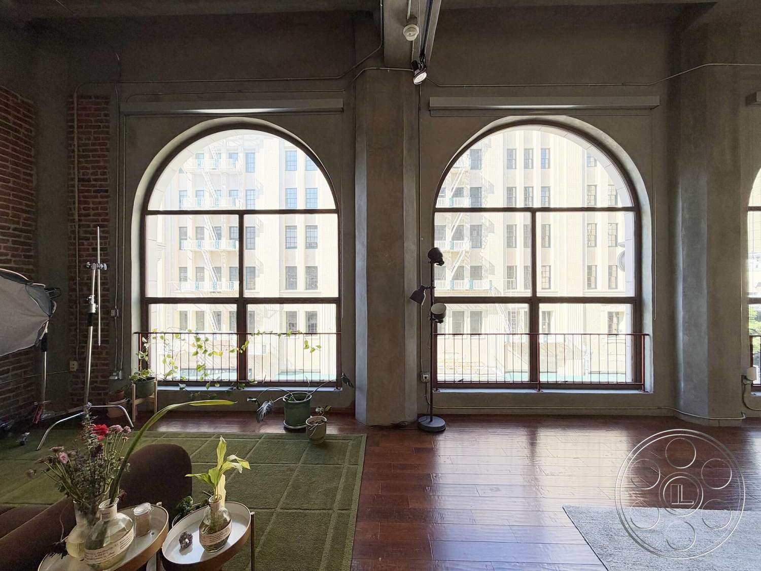 Brockman 310 - open floor plan, concrete walls, urban setting, floor-to-ceiling windows, industrial lighting fixtures, sliding glass door, arched windows, hardwood living room floors, exposed brick accent wall, textured concrete ceiling