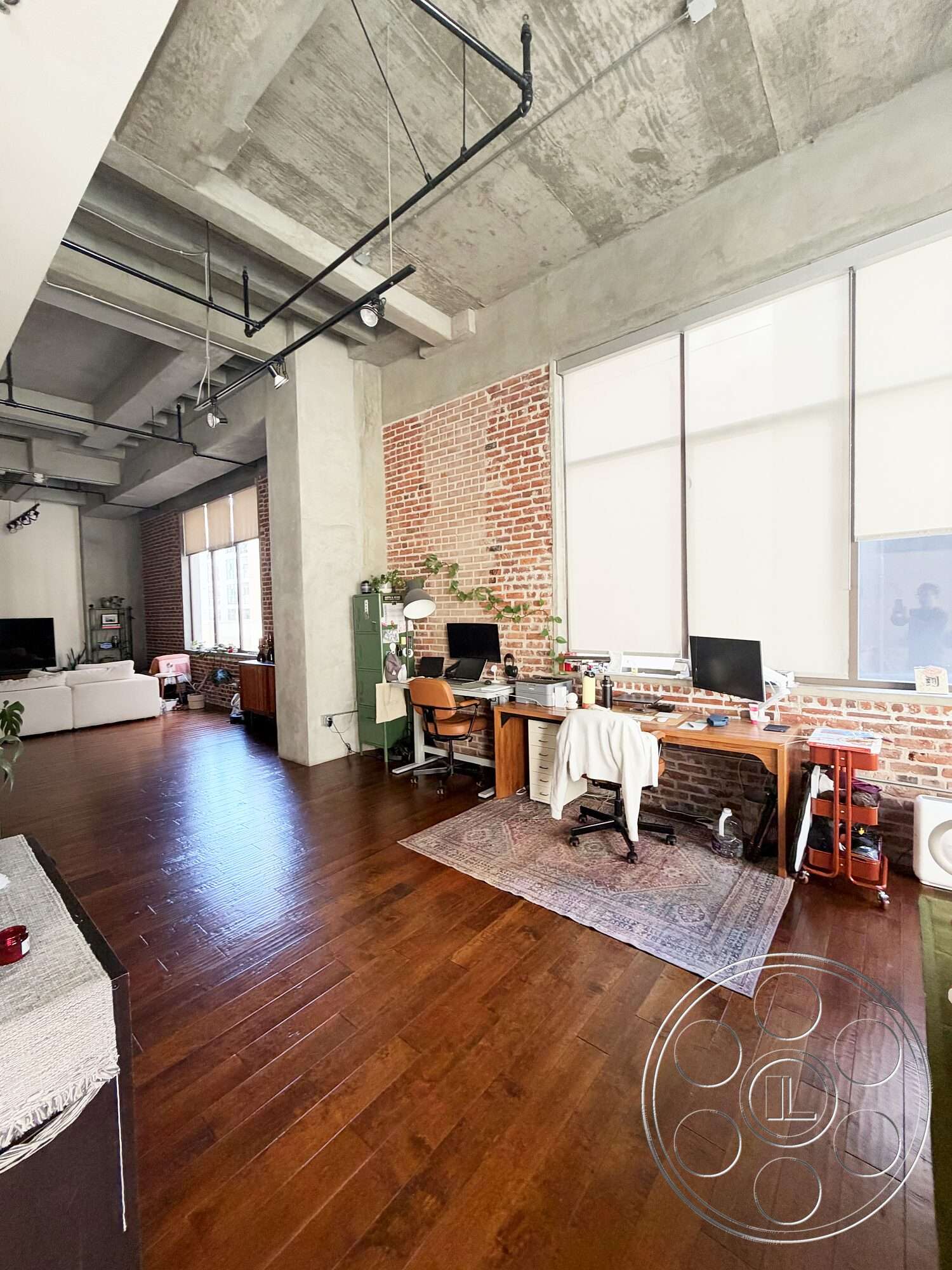 Brockman 310 - minimalist decor, natural light, hardwood flooring, open floor plan, area rug, modern aesthetic, industrial style, floor-to-ceiling windows, exposed brick accent wall, concrete ceiling panels, metal piping details, office area with desks
