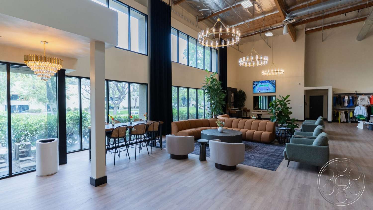 Gym 38 - indoor plants, textured area rug, light hardwood flooring, glass partition, large floor-to-ceiling windows, black accent wall, contemporary coffee table, soft lighting ambiance, wood beam ceiling, modern sectional sofa, chandelier lighting fixtures, wide window view, bar-style seating