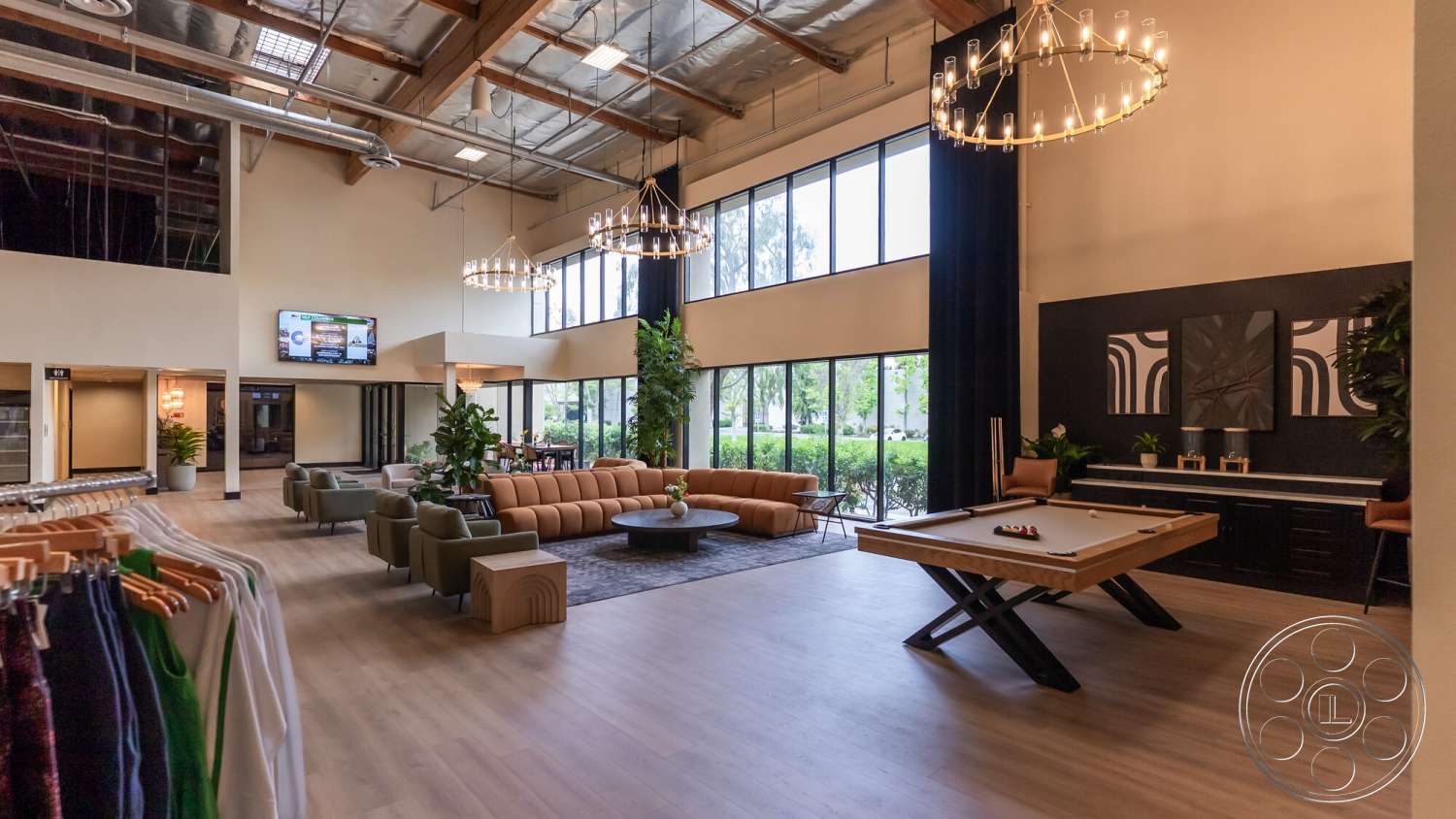 Gym 38 - light hardwood flooring, floor-to-ceiling windows, pool table, black accent wall, industrial light fixtures, contemporary coffee table, exposed wood ceiling beams, modern sectional sofa, potted indoor plants, open floor plan living area, interior lounge space, charming lounge area