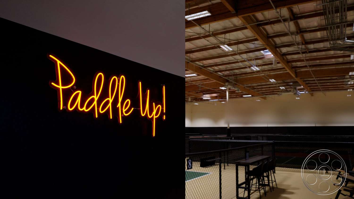 Gym 38 - industrial lighting, metal chairs, wooden tables, exposed wood ceiling beams, black wall treatment, neon sign 'Paddle Up!', sports court flooring, fence partition